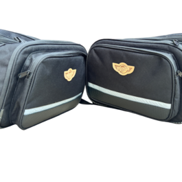 Two black travel bags with a tan guardian gear logo patches side by side on a white background highlight the brand decal and zippered pockets.