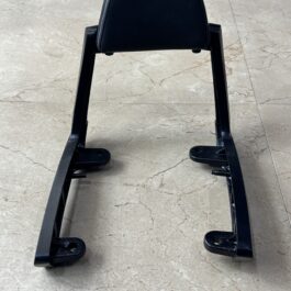 IMG_9147 - laxmiautocare.com Black padded backrest mounted on a metal frame with bolt holes, seen from behind/in a workshop setting.