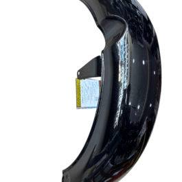 Close-up of a glossy black curved car fender with a small label tag attached to its edge