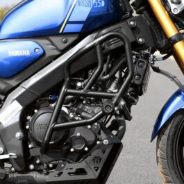 Close-up of a blue Yamaha motorcycle showing the engine, frame protection bars, and front suspension with the Yamaha logo visible on the side panel