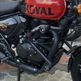 Screenshot - laxmiautocare.com Close-up of a Royal Enfield Hunter 350 motorcycle with a red fuel tank and black engine guard.