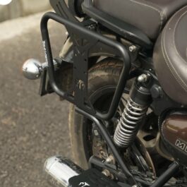 Screenshot - laxmiautocare.com Rear view of a motorcycle with a black metal luggage rack and chrome rear shocks visible behind the seat? (informative)