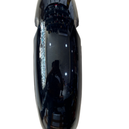 Close-up of a glossy black curved surface reflecting a person taking the photo.