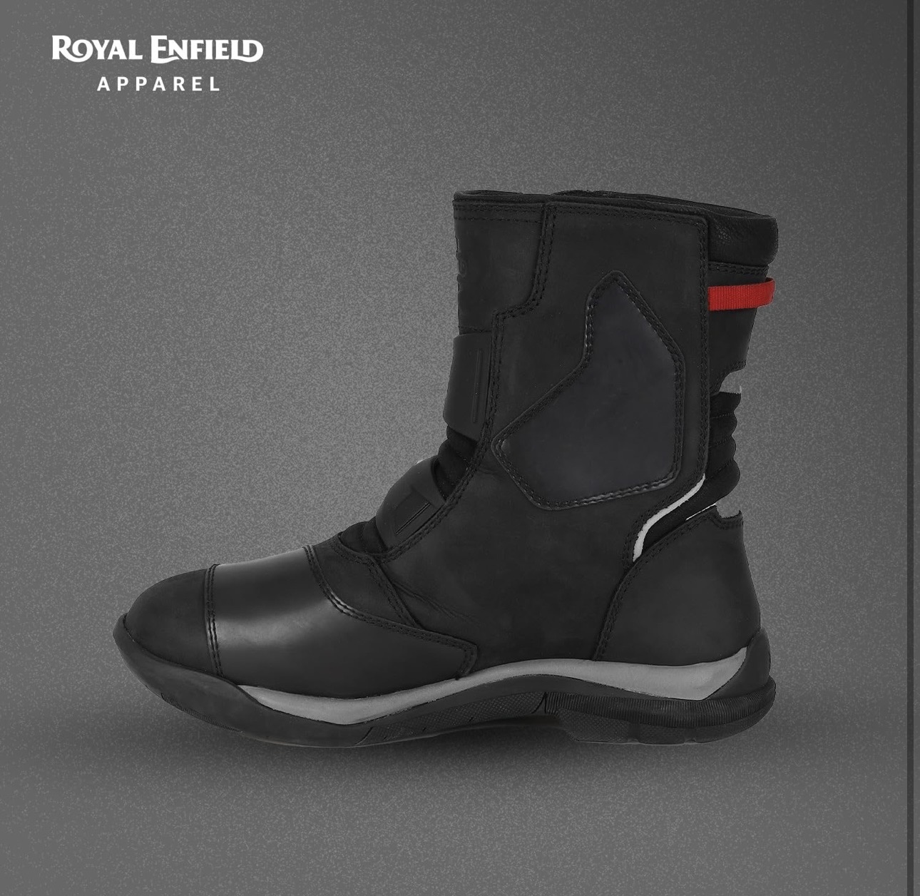 Screenshot - laxmiautocare.com Royal Enfield Apparel black riding boot with a red pull tab, shown in side profile against a gray background