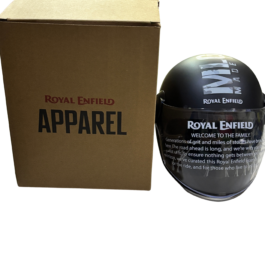 Brown cardboard Royal Enfield Apparel box next to a black glossy Royal Enfield helmet with white logo on a black background.