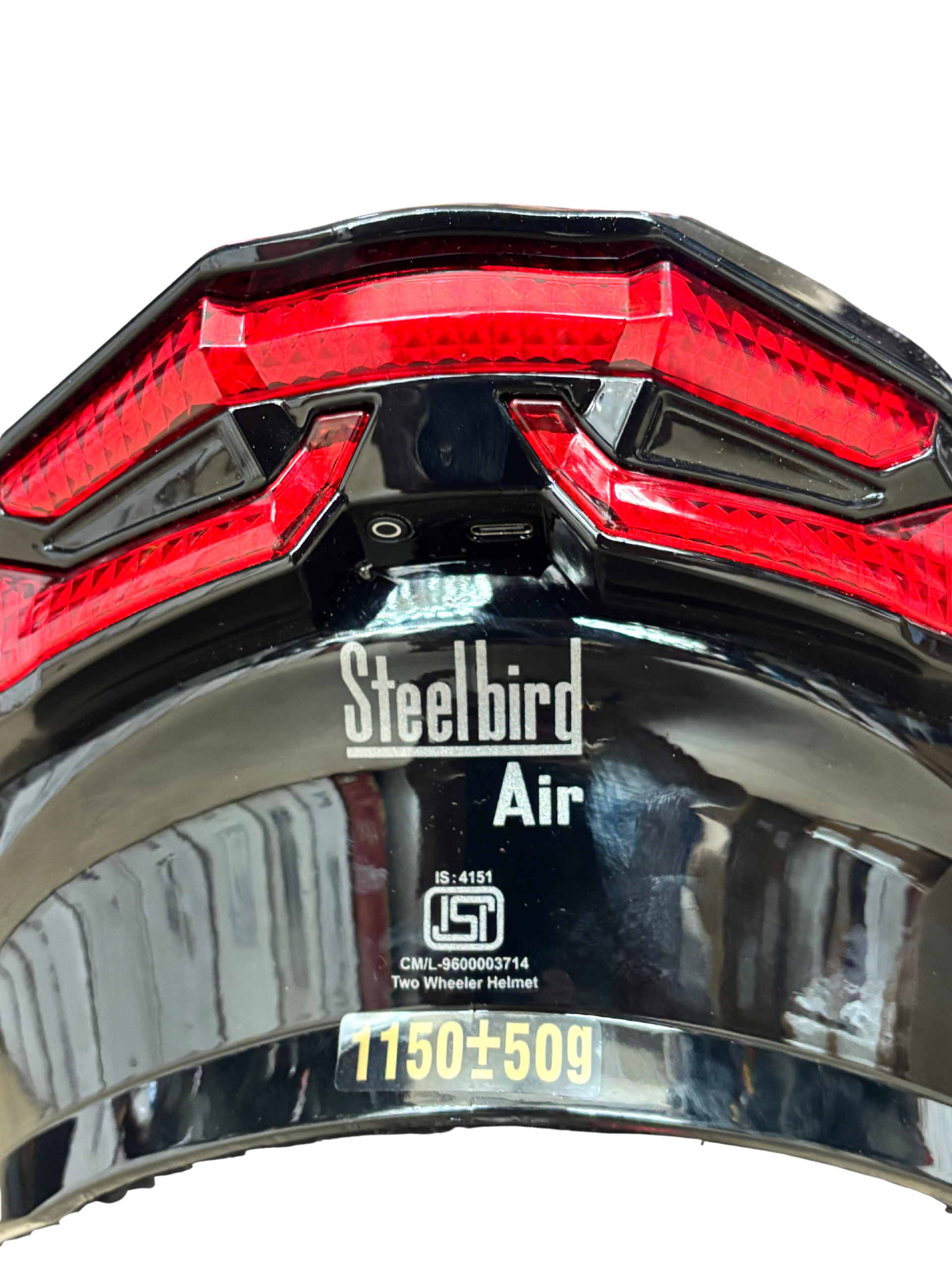 53b6953b-9450-4647-bdd5-55f41b13c754 - laxmiautocare.com Back view of a black Steelbird helmet with a red geometric taillight panel and the 'Steelbird Air' label at the bottom center.