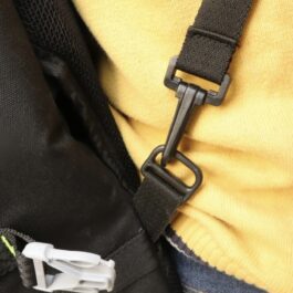 Screenshot - laxmiautocare.com Close-up of a black backpack strap buckle clipped to a yellow garment, showing a plastic buckle and metal ring.