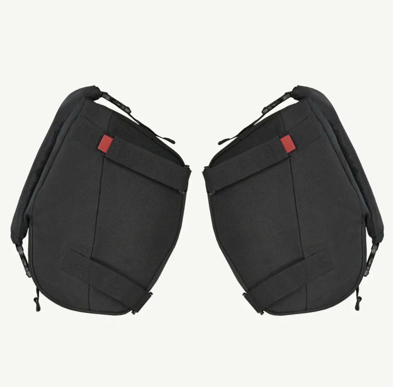 Screenshot - laxmiautocare.com Pair of black motorcycle pannier bags facing each other with straps and zippers visible on a light background.
