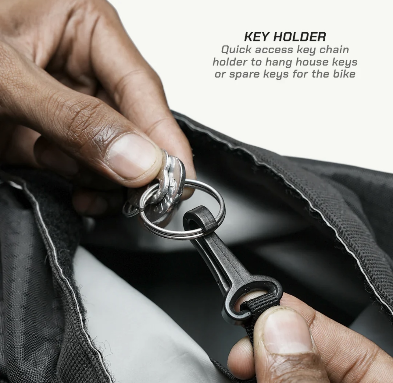 Screenshot - laxmiautocare.com Close-up of hands attaching keys to a black quick-access key holder.