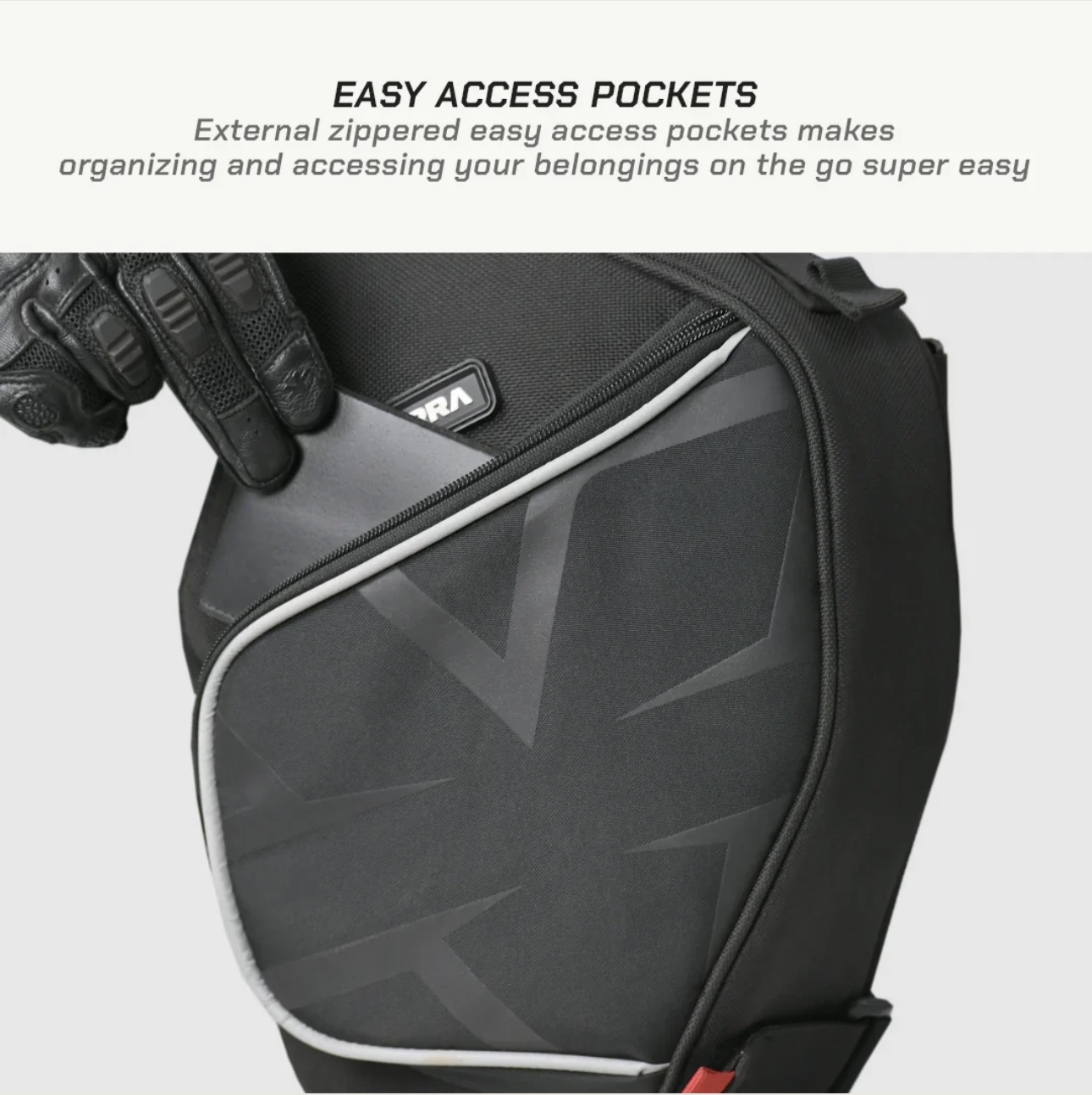 Screenshot - laxmiautocare.com Close-up of a gloved hand placing a card into a front zippered pocket of a black backpack, highlighting easy-access pockets.